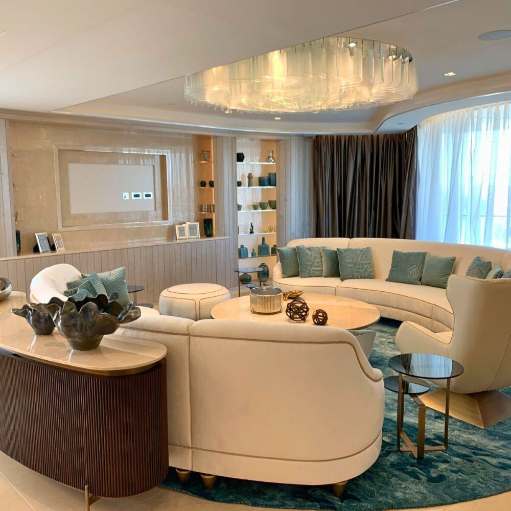 Curved sofa and modern chandelier in central living room.