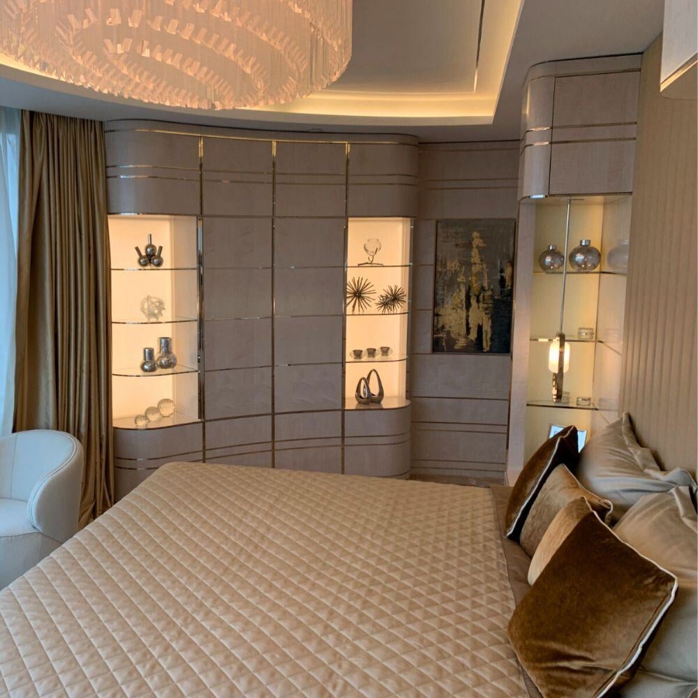 Master bedroom with bespoke illuminated display wall and soft furnishings.