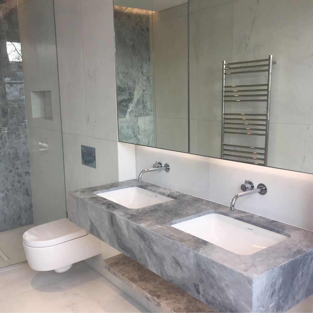 High-end bathroom with grey marble double sink vanity, walk-in shower, and large mirrored wall in Belgravia.