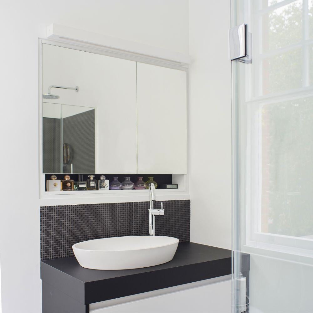 Minimalist bathroom with black countertop sink and built-in mirrored cabinet in Evelyn Gardens refurbishment.