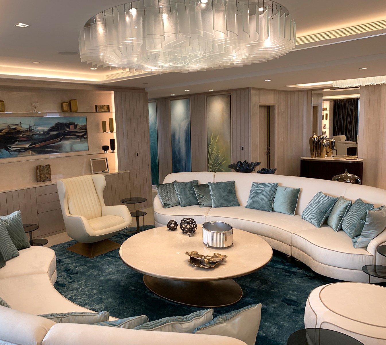 Elegant bespoke living room with plush curved seating, glass chandelier, and custom decor, ideal for high-end residential and fit-out projects.