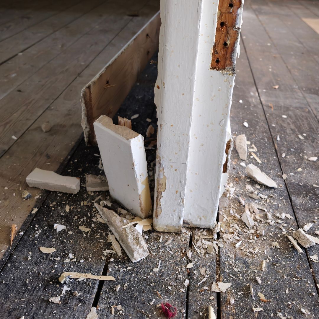 Damaged skirting board and wall frame exposed during home demolition
